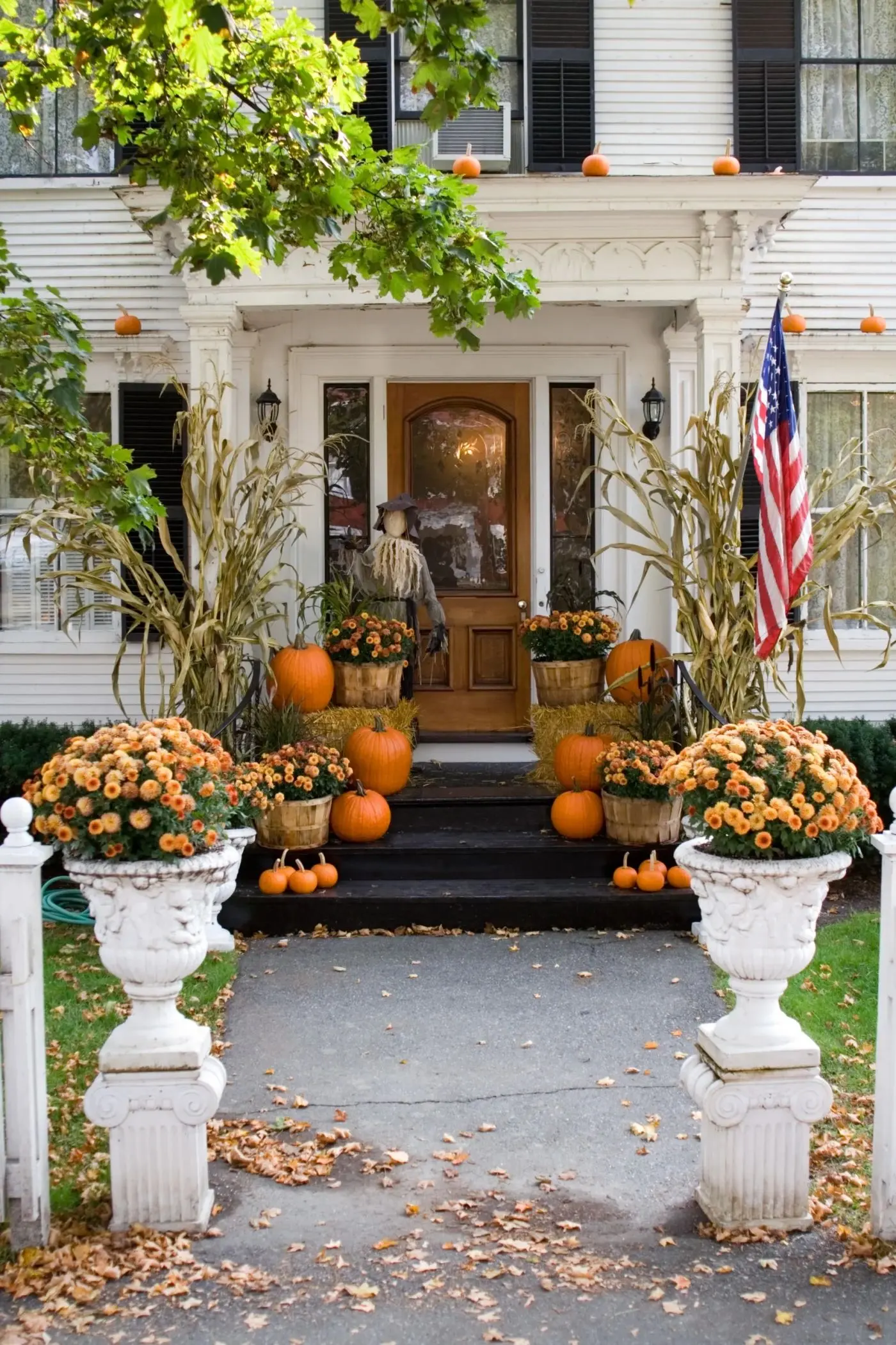 Fall porch installation with pumpkins layered up the steps
